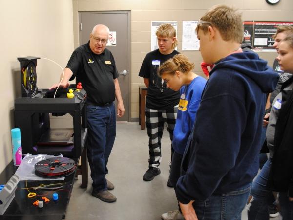 college instructor Paul Smith with group of students and 3D printer
